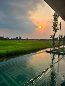 a body of water with the sunset in the background at BEAUCHAMP VILLA in Ấp Bình Yên