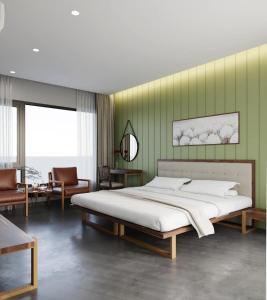 1 dormitorio con cama y pared verde en BEAUCHAMP VILLA, en Ấp Bình Yên