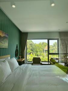 a bedroom with a large bed and a large window at BEAUCHAMP VILLA in Ấp Bình Yên