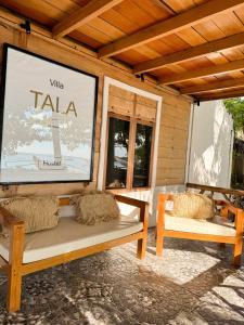 a screened in porch with two benches and a screen at Villa Tala in Tua Pejat