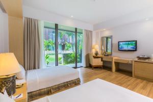 una camera d'albergo con letto e scrivania di Le Grande Bali a Uluwatu