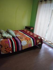 a bedroom with a bed with a colorful blanket on it at Hotel Tradiciones Quito Foch in Quito