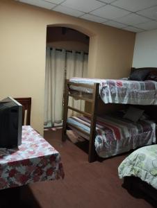 a room with two bunk beds and a tv at Hotel Tradiciones Quito Foch in Quito
