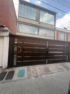 a building with a brown garage door in front of a building at Hermoso apartamento cerca al aeropuerto! in Bogotá