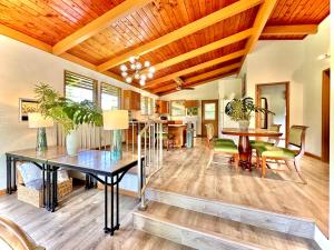a dining room and living room with a wooden ceiling at Home near Volcano National Park, Hilo, Kehena in Keaau