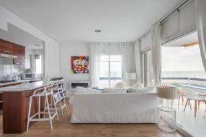 ein Wohnzimmer mit einem weißen Sofa und einer Küche in der Unterkunft Sunset Boutique Castelldefels by MyRentalHost in Castelldefels