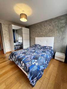 a bedroom with a bed with a blue comforter at Villa Alia in Gérardmer