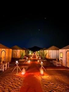 een groep tenten in de woestijn 's nachts bij Deep Desert Camp in Merzouga