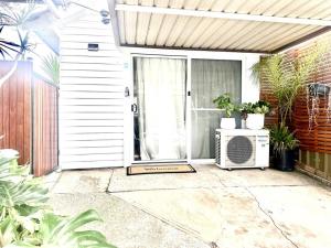 a front door of a house with a fan on a patio at Happy Studio in NewCastle in Minmi
