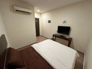 Un pat sau paturi într-o cameră la Ezzy In Hotel