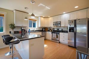uma cozinha com armários brancos e um frigorífico de aço inoxidável em Stylish North Seattle Townhouse- Dual Master Suites em Seattle