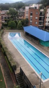 an overhead view of a swimming pool with a blue roof at Habitación dentro de un Apartamento compartido in Ibagué