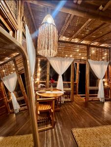 una sala da pranzo con tavolo e lampadario pendente di Montelena Glamping a Vergara