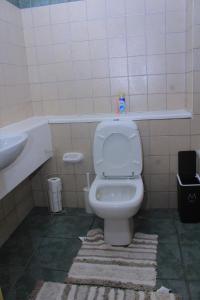 a bathroom with a white toilet and a sink at Cozy stay in Gaborone