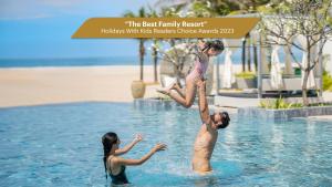 濠莊的住宿－Melia Ho Tram Beach Resort，三人在度假村的水中玩耍