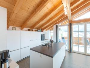 ブリクセン・イム・ターレにあるLuxury penthouse with Balcony Ski Storage Carport Liftの木製の天井、白い家電製品付きのキッチン