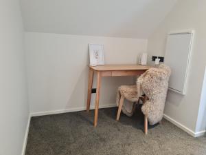 a desk in a room with a chair and a table at Woolshed retreat - Queenstown in Queenstown
