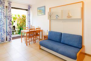 a living room with a blue couch and a table at Residence Europa in Sistiana