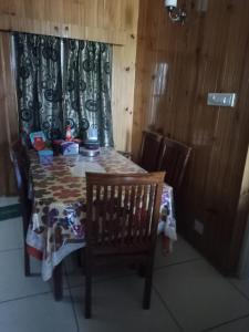 Pokój ze stołem, krzesłem i zasłoną w obiekcie OYO Home Ekant Kutir Homestay w mieście Kūd