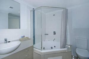 a bathroom with a shower and a sink and a toilet at Ettalong Beach Luxury Apartments in Ettalong Beach