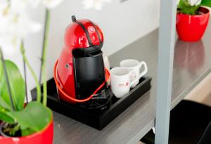 a red iron sitting on a shelf with cups at Hostal Carmen-Gran Vía in Madrid