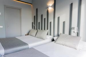 dwa łóżka siedzące obok siebie w pokoju w obiekcie Hostal Carmen-Gran Vía w Madrycie