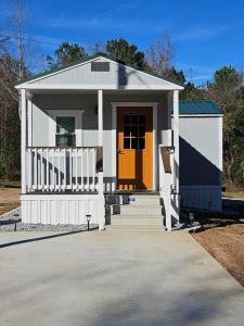 una piccola casa con porta arancione e scale di Studio 431-Vet owned 14 miles to Ft Moore a Phenix City