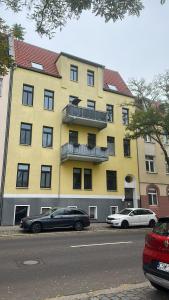 ein gelbes Gebäude mit davor geparkt in der Unterkunft Über den Dächern von Halle in Halle an der Saale