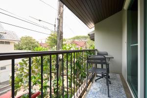 a balcony with two chairs and a table at Teera villa chiang mai ทีร่าวิลล่าเชียงใหม่ in Chiang Mai