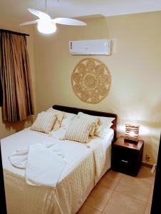 皮帕Pipa beleza SPA Resort_Chalé Duplex/Jacuzzi的一间卧室配有一张带白色床单的床和风扇