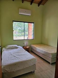 2 camas en una habitación con ventana en HERMOSA CASA DE 3 DORMITORIOS en San Bernardino