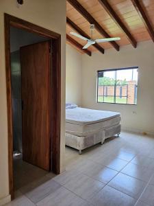Un dormitorio con una cama y un ventilador de techo. en HERMOSA CASA DE 3 DORMITORIOS, en San Bernardino