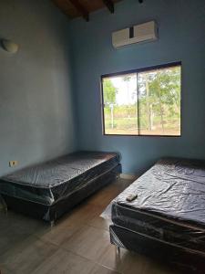 - 2 lits dans une chambre avec fenêtre dans l'établissement HERMOSA CASA DE 3 DORMITORIOS, à San Bernardino