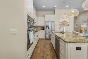 フォートマイヤーズビーチにある3134 Estero Blvd homeのキッチン(白いキャビネット、大理石のカウンタートップ付)