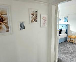 una habitación con fotos en la pared y un dormitorio en Charming 3-Bed Oasis-free parking en Glasgow