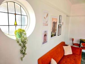 ein Wohnzimmer mit einem orangenen Sofa und einem Fenster in der Unterkunft Charming 3-Bed Oasis-free parking in Glasgow