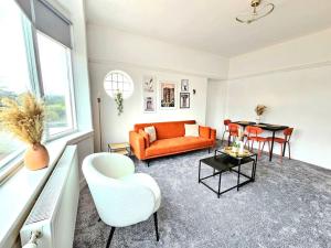 ein Wohnzimmer mit einem orangenen Sofa und einem Tisch in der Unterkunft Charming 3-Bed Oasis-free parking in Glasgow