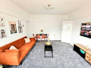 ein Wohnzimmer mit einem Sofa und einem Tisch in der Unterkunft Charming 3-Bed Oasis-free parking in Glasgow