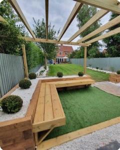 una mesa de picnic de madera en un jardín con hierba en York huntington Holiday let en York