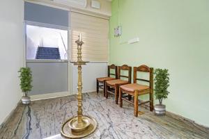 une chambre avec des chaises, une table et une fenêtre dans l'établissement OYO Poptavern Premium, à Trivandrum