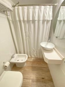 a white bathroom with a toilet and a sink at Apartamento en Gorlero in Punta del Este