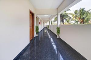 un couloir vide d'un bâtiment avec des plantes dans l'établissement OYO Poptavern Premium, à Trivandrum
