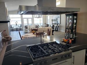 a kitchen with a stove and a living room at EdgeWater Chemainus in Chemainus