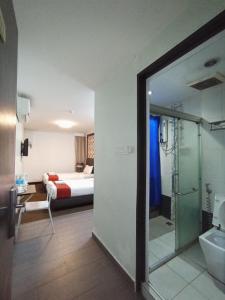 a bedroom with a bed and a bathroom with a shower at Warisan Hotel Kota Kinabalu in Kota Kinabalu