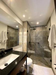 een badkamer met een douche, een toilet en een wastafel bij Espectacular Apto Loft - La Candelaria, Bogotá in Bogota