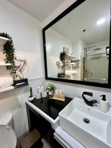 a bathroom with a sink and a large mirror at SMDC Wind Tagaytay in Tagaytay