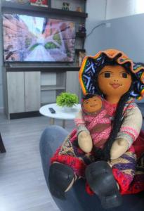 a doll sitting on a chair in a living room at ¡Departamento Puñuy Wasi! in Cusco