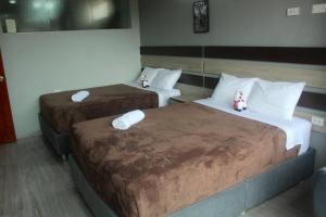 two beds in a hotel room with towels on them at ¡Departamento Puñuy Wasi! in Cusco