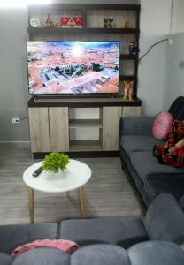 a living room with a couch and a flat screen tv at ¡Departamento Puñuy Wasi! in Cusco