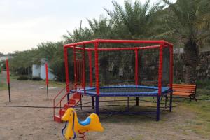 a playground with a bird cage and a slide at Hatta Hills in Al Ḩajarayn
